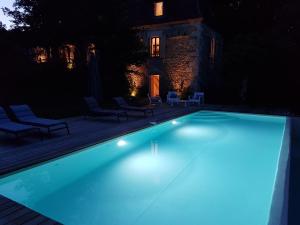 a swimming pool at night with blue lights at Gîte de Chantegrel in Fleurac