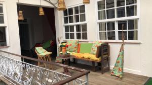 a porch with a couch and chairs on a balcony at Palma Hostel in São Luís