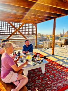 Um homem e uma mulher sentados à mesa com comida. em Zukhro Boutique Hotel em Khiva