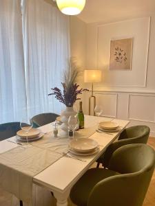 a dining room table with chairs and a white table with wine glasses at JungleClassic en plein cœur de Mulhouse in Mulhouse