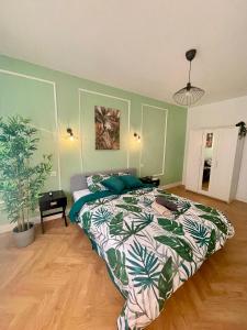 a bedroom with a bed with a green wall at JungleClassic en plein cœur de Mulhouse in Mulhouse