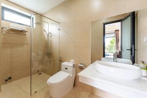 a bathroom with a toilet and a sink and a shower at Villa Charming Hoi An in Hoi An +28 photos