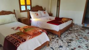 sypialnia z 2 łóżkami z białą pościelą w obiekcie Auberge Restaurant Targa Taliouine w mieście Taliouine