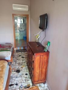 a room with a tv on a wall with a dresser at Auberge Restaurant Targa Taliouine in Taliouine