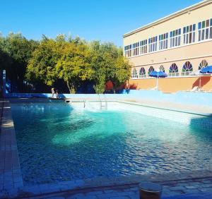 una gran piscina de agua frente a un edificio en Auberge Restaurant Targa Taliouine en Taliouine