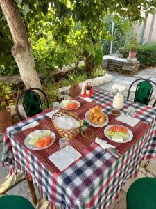 una mesa de picnic con platos de comida. en MiziriGuestHouse, en Gjirokastra