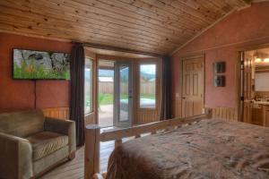 a bedroom with a bed and a chair and a window at Stapp Mountain Retreat in South Fork, CO in South Fork