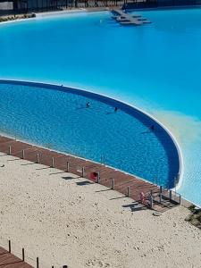 a large swimming pool on a beach next to the water at Departamento con vista al mar en Condominio Lagunamar in Las Cruces