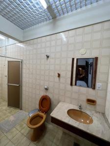 a bathroom with a toilet and a sink and a mirror at Pousada Giramundo in Teixeiras