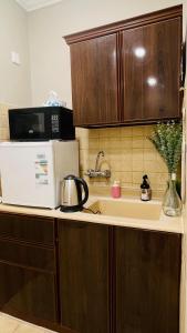 a kitchen with a sink and a microwave at شقة خاصة بتصميم مختلفة وجميل في موقع ممتازEntire apartment in Al Ahsa