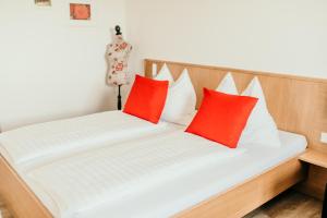 a bed with two red pillows on it at Titscherhof in Leutschach