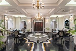 a restaurant with tables and chairs and a chandelier at Kaner Bagh A Heritage Boutique Hotel in Udaipur