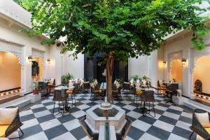 a restaurant with a tree in the middle of a floor at Kaner Bagh A Heritage Boutique Hotel in Udaipur