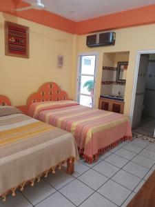 a bedroom with two beds and a bathroom with a sink at El Tucan in Puerto Escondido +44 photos