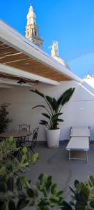 a patio with two benches and a table and a plant at Lithos house pt 1p e 2p in Monopoli