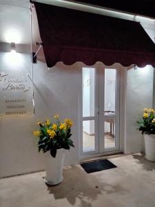 Pokój z dwoma wazami kwiatów i drzwiami w obiekcie Giardino dei Baroni house w mieście Marina di Mancaversa