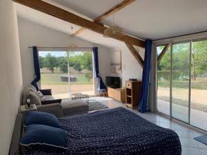 1 dormitorio con cama, sofá y ventana en Petite maison, en Gabarret