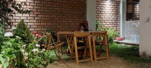 una mesa de madera y sillas junto a una pared de ladrillo en Jull complete house with 8 bedrooms and 6 bathroom, en Cusco