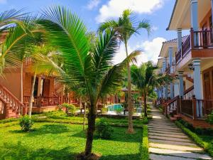 a row of palm trees in front of houses at Valentina Resort & Spa Phu Quoc in Phú Quốc