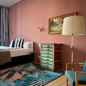 a bedroom with a bed and a dresser and a lamp at Brilliant Apartments in Berlin
