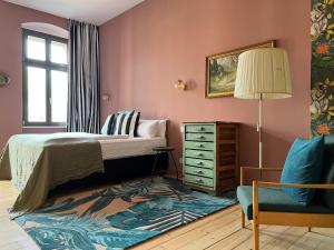 a bedroom with a bed and a dresser and a chair at Brilliant Apartments in Berlin