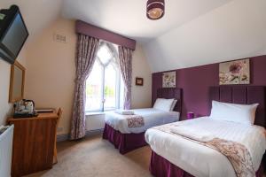 1 dormitorio con 2 camas y ventana en The Lemon Tree, en Wrexham