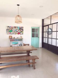 ein Zimmer mit Holztischen und einer blauen Tür in der Unterkunft Moderna casa en las Paredes a 1 km del aeropuerto in San Rafael