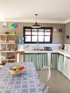 eine Küche mit einem Tisch mit einer Obstschale darauf in der Unterkunft Moderna casa en las Paredes a 1 km del aeropuerto in San Rafael + 13 Fotos