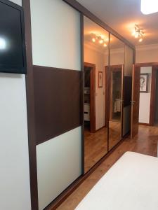 a bedroom with a mirror and a tv on a wall at Ático gran manzana granada in Granada