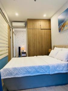 een slaapkamer met een groot bed en een houten kast bij Son Thuy's House -Luxury Apartment The Sóng Vũng Tàu in Vung Tau