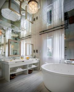 a bathroom with a tub and two sinks and a large mirror at Belfry & Spa by Ligne St Barth in Lourdes