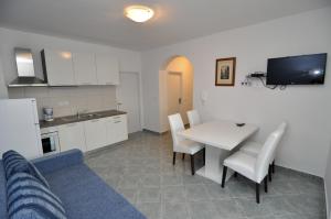 cocina y comedor con mesa blanca y sillas en Apartments Marija - Maslenica en Maslenica