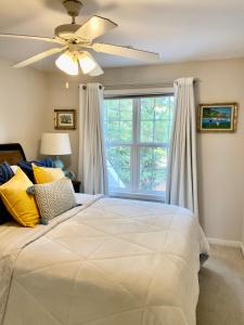 een slaapkamer met een bed, een plafondventilator en een raam bij Suite Melissa's Pinehurst Country Club #6 Private Room and Bath in Pinehurst