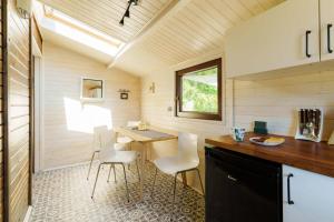 a kitchen with a table and chairs in a tiny house at Domek letniskowy nad jeziorem in Łąck