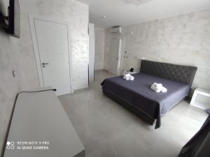 un dormitorio con una cama con dos animales de peluche en Hotel Paladini, en Porto Cesareo