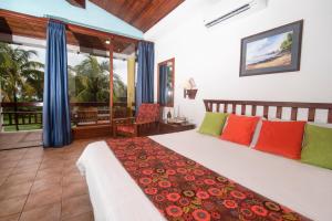 a bedroom with a large bed with colorful pillows at Nandel Beach Resort in La Cruz