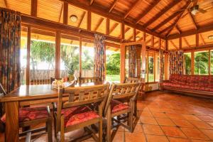 comedor con mesa, sillas y sofá en Nandel Beach Resort en La Cruz