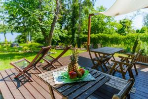 a plate of fruit on a table on a deck at Domek letniskowy nad jeziorem in Łąck