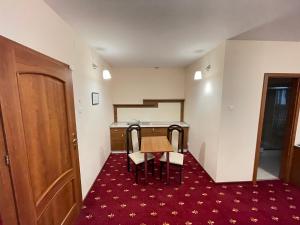 una piccola camera con tavolo, sedie e scala di Hostel Paltinis a Hunedoara