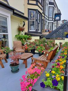 a patio with benches and flowers in front of a building at No 6 Quality Guesthouse in Llandudno