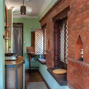 a kitchen with a brick wall and a brick oven at New Orleans Apartment in Kathmandu