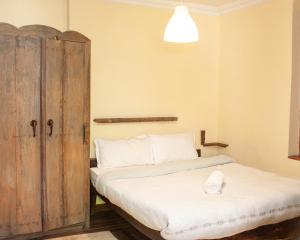 a bedroom with a bed and a wooden door at New Orleans Apartment in Kathmandu