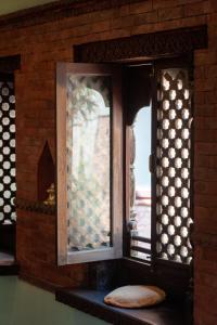 a window in a brick wall with a pillow next to it at New Orleans Apartment in Kathmandu