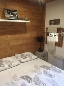 two beds in a bedroom with a wooden wall at Cocoonabay Appartements 8 in Les Angles