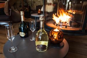 a table with two bottles of wine and wine glasses at Chalet le Bonheur in Méribel