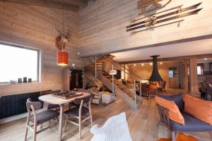 a living room with a table and chairs and a staircase at Chalet le Bonheur in Méribel