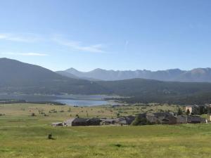 uma vista para um vale com um lago e montanhas em Cocoonabay Appartements 8 em Les Angles