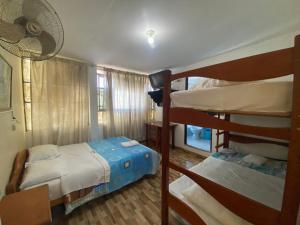 1 Schlafzimmer mit 2 Etagenbetten und einem Ventilator in der Unterkunft HOSTAL HOGAR 3 Estrellas - CHEPÉN in Chepén