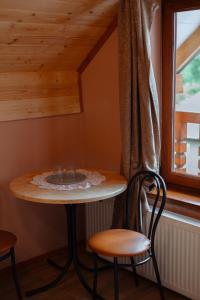 mesa pequeña con 2 sillas y ventana en Садиба над потоком, en Lumshory