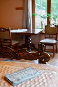 una silla de madera en una habitación con mesa y sillas en Садиба над потоком, en Lumshory